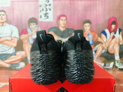 Rear view of the black and gray Nike sneakers showing heel pull tabs, textured heel panels, and outsole details.