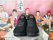 Front view of black Nike Kobe basketball shoes with black laces and gold tongue details