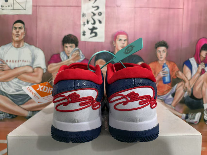 Rear view of white, navy blue, and red Nike sneakers with red heel details and dark blue outsoles.