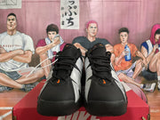 Front view of black and silver Nike sneakers with orange accents