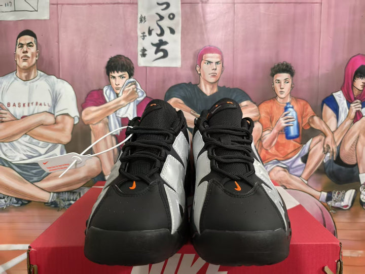 Front view of black and silver Nike sneakers with orange accents