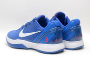 Rear three-quarter view of blue sneakers with padded collars, red number 8 details, and signature-style heel markings.