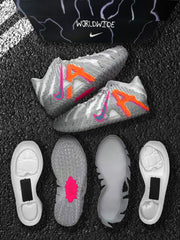 Pair of grey basketball sneakers with orange and pink side graphics, shown with outsole and sole construction pieces.