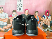 Rear view of black Nike basketball shoes with white heel accents and speckled midsoles.