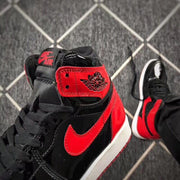 Close-up of the red ankle flap, black upper, red side detail and padded tongue.