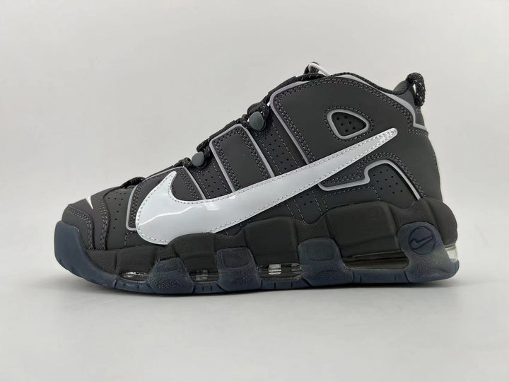 Side view of a black and dark gray Nike low-top sneaker with a large silver Swoosh and chunky segmented sole