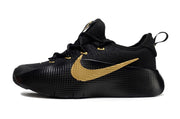 Side profile of a black sneaker with a gold swoosh-style side mark.