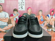 Front view of black Nike sneakers showing black laces, small gray tongue swooshes, padded collars, and translucent-looking outsoles.