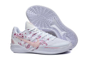Side view of a white basketball shoe with a pink Swoosh, floral graphics, and patterned outsole.