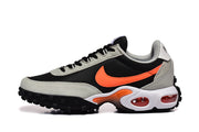 Side view of a Nike Air Max Waffle SP sneaker with black upper, gray overlays, orange swoosh, and white cushioning midsole.