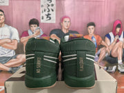 Rear view of the green sneakers showing contrasting heel stripes and the text “NO SERVICE” and “FLAGSTAFF.”
