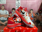 Angled view showing the black side branding, white patterned upper, red details, and red outsole.