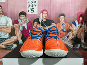 Front view of orange basketball shoes with blue laces and white outsoles
