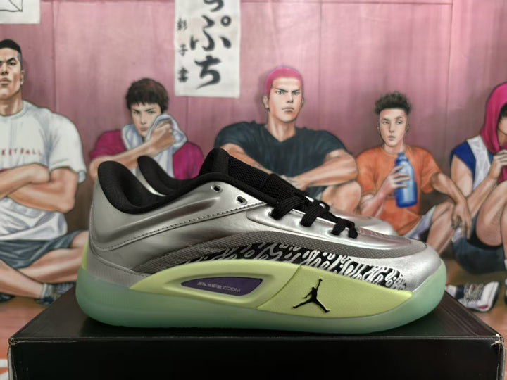 Side view of silver Jordan basketball sneakers with black laces, patterned side panel, and green outsole area.