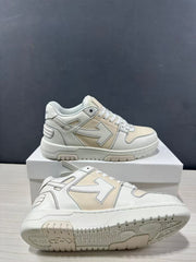 Angled view of the sneakers showing the cream-white upper, outlined arrow motif and outsole tread.