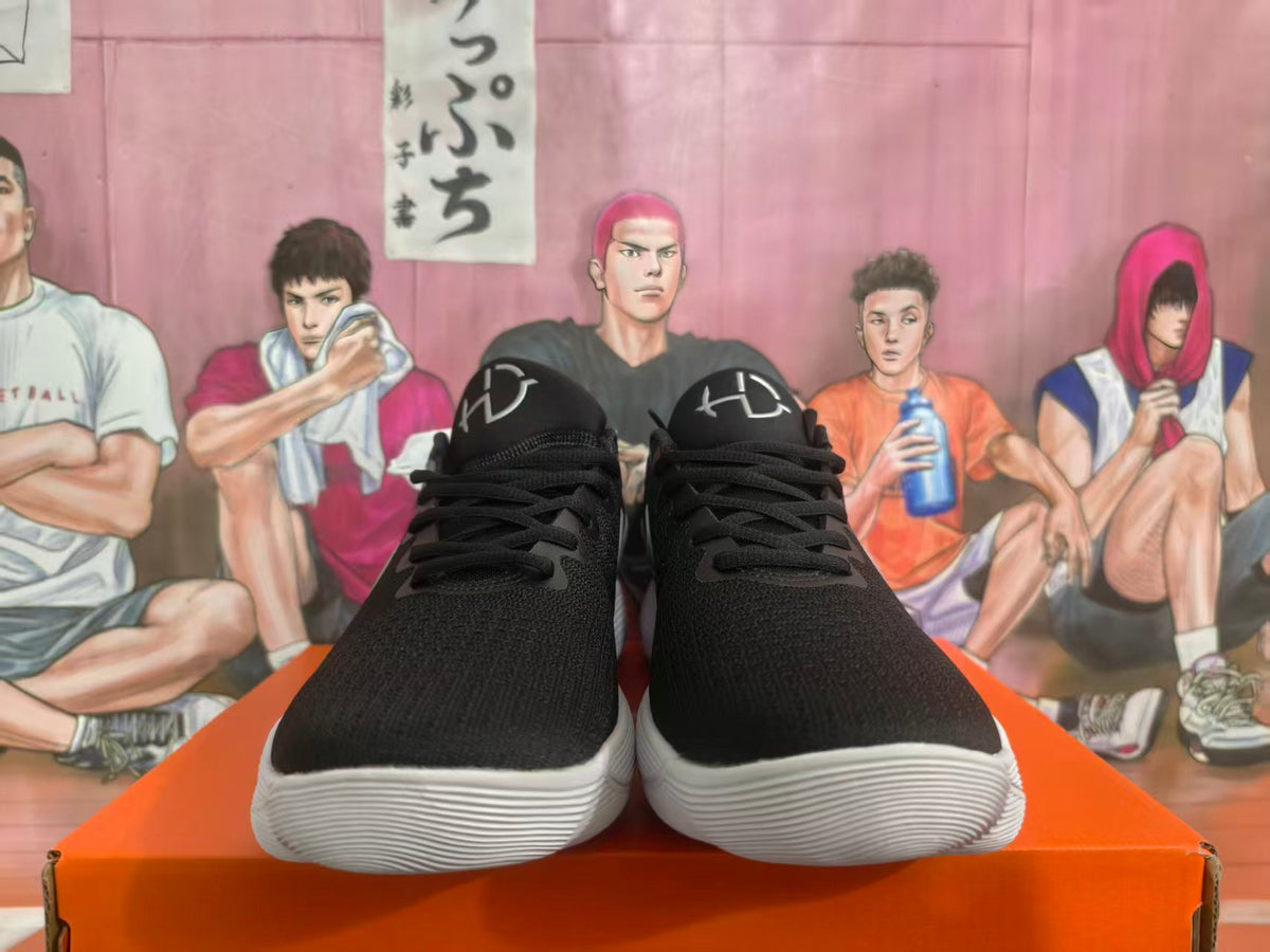 Front view of black Nike sneakers with silver tongue details and white ridged soles.