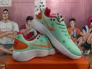 Two mint green Nike sneakers displayed together, showing orange Swooshes, red accents, and white textured soles.