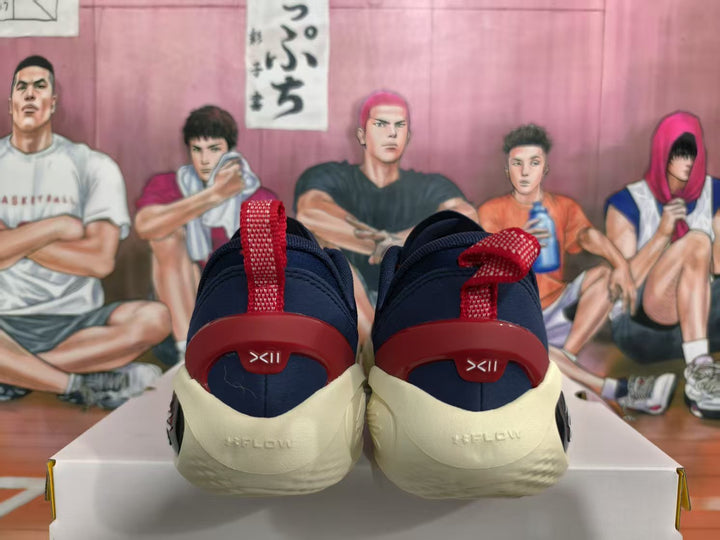 Rear view of navy blue basketball sneakers with red heel pull tabs and cream-colored midsoles.