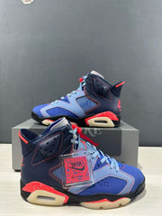 Side view showing layered blue and navy panels, perforations, red stitching, and the visible heel Air window.