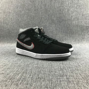 Pair of black and grey Air Jordan 1 Mid sneakers shown from a front three-quarter angle.