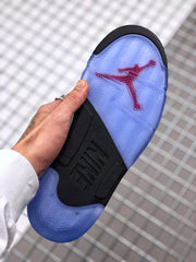Bottom view showing the translucent blue outsole, red Jordan graphic, black midfoot section, and patterned tread.