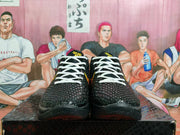 Front view showing the textured black upper, white laces, and yellow tongue emblems