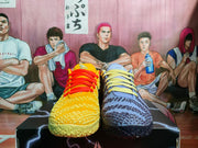 Yellow-and-blue mismatch basketball sneakers shown from the front with contrasting red and yellow laces.
