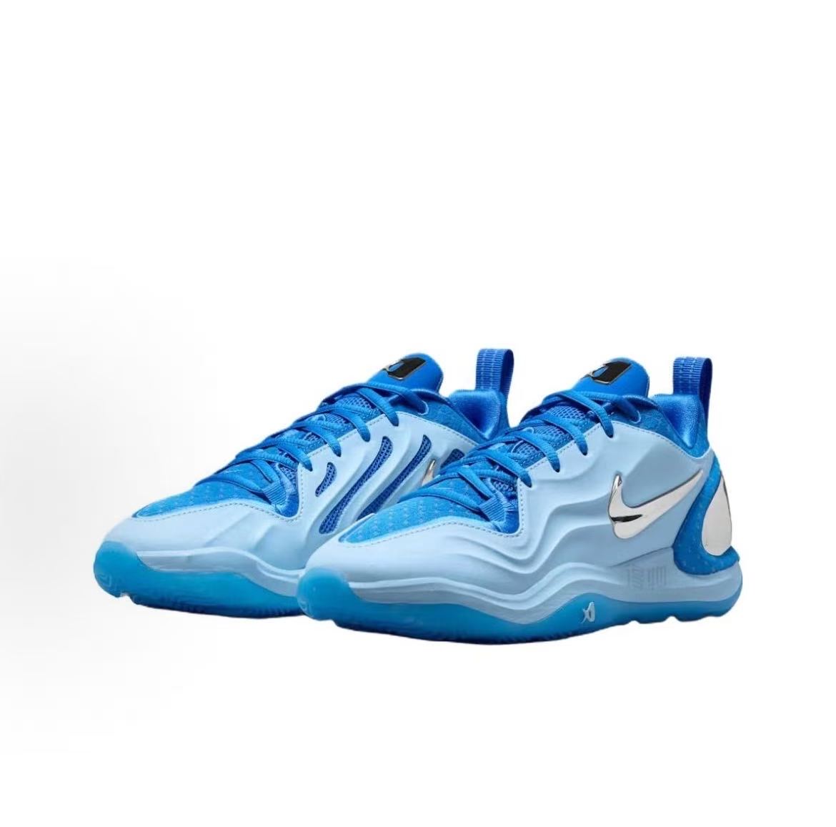 Pair of ocean blue Nike sneakers with layered panels, blue laces, contrasting Swooshes, and sculpted soles on a white background.