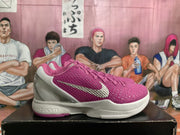 Side profile highlighting the pink textured upper, metallic silver Swoosh, white midsole, and pink outsole edge.