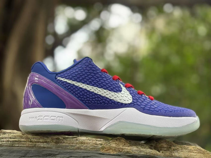 Side view of purple and blue Nike Kobe 6 sneakers with a white Swoosh, red laces, and translucent purple heel panel.
