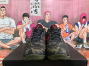 Front view of Nike Kobe camouflage sneakers with black laces, red tongue details and textured camouflage uppers.