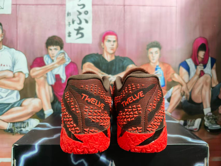 Rear view of red and dark basketball sneakers showing TWOLVES lettering, textured uppers, and sculpted red outsoles.