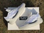 Angled view of the white Jordan 39 sneakers with the model-labeled box