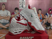 Angled view showing the white and red Nike sneakers with textured midsoles and outsoles.