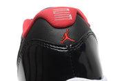 Close-up of the heel showing a red embroidered Jumpman-style logo, red heel tab, and glossy black heel panel.