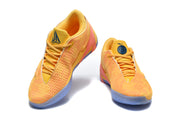 Pair of yellow and orange Nike basketball shoes shown from the front at an angle