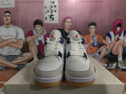 Front view of white and navy high-top sneakers showing Jordan tongue branding, mesh panels, and gum-colored soles.