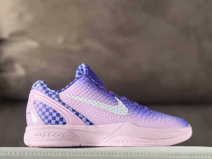 Side profile of violet and pink gradient Nike Kobe 6 sneakers with a textured upper, light-colored Swoosh, checkerboard heel panel, and pink midsole.
