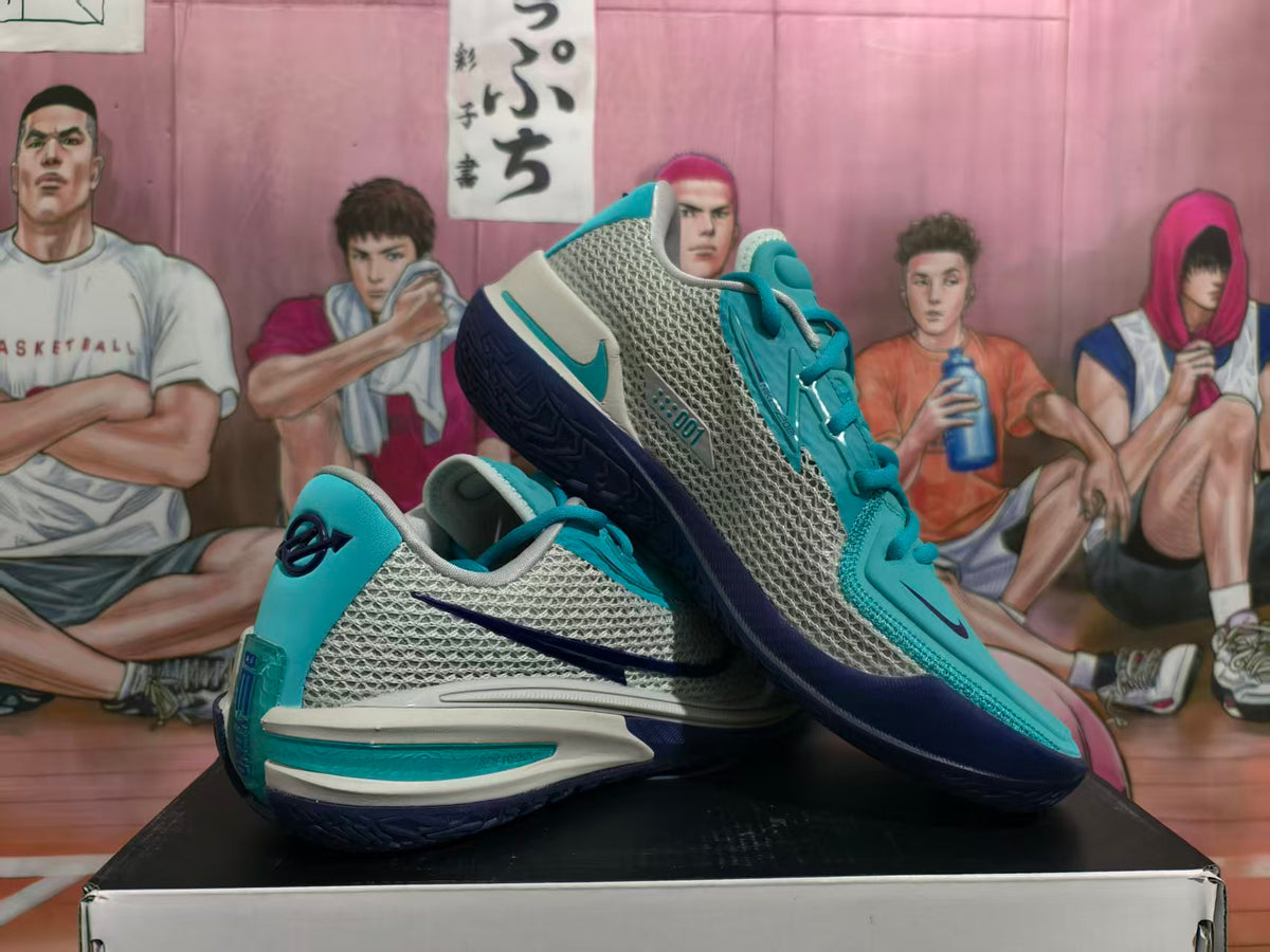 Pair of blue, grey, white, and navy Nike GT Cut 3 basketball shoes shown at an angle