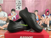 Angled view of two black Nike sneakers showing the layered upper, ventilation openings, and volt-green Swoosh.