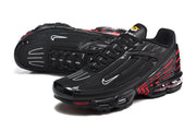 Angled view of black Nike Air Max Plus III sneakers with red side detailing.