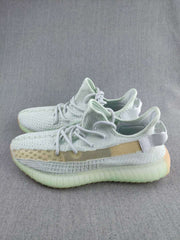 Two pairs of pale green and beige knit sneakers shown in a three-quarter side view.