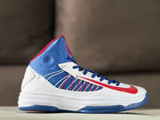 Side profile of a white, blue, and red Nike high-top basketball sneaker.