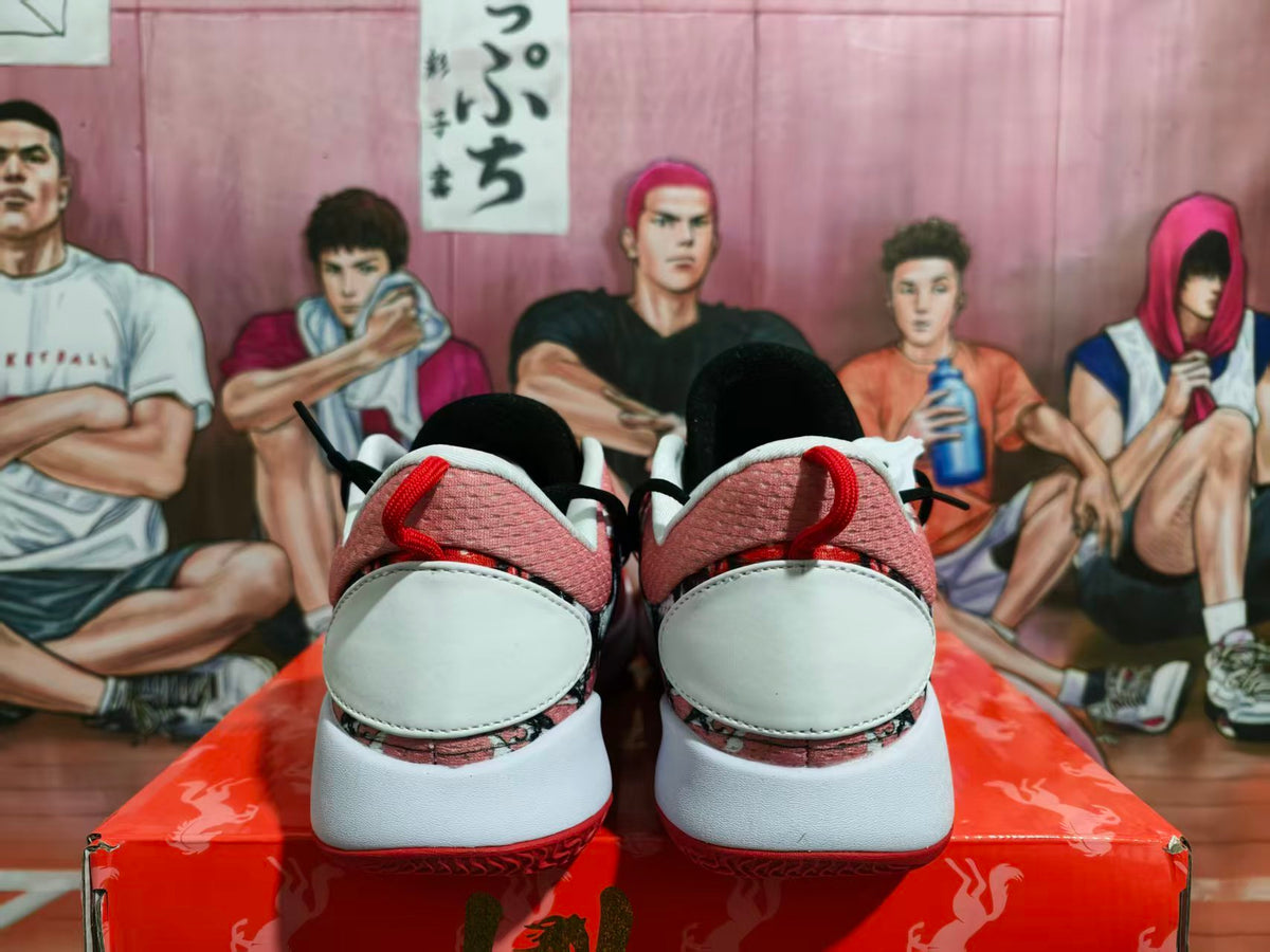 Rear view of pink, black, white, and red Nike basketball-style sneakers displayed on a red box.