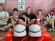 Rear view of pink, black, white, and red Nike basketball-style sneakers displayed on a red box.