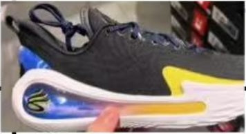 Side view of a black Nike LeBron basketball shoe with green and yellow accents and a visible Air unit in the sole.