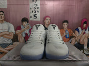 Front view of a pair of white Nike basketball shoes with black tongue logos and blue-toned outsoles.