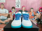 Front view of white Nike Kobe basketball shoes with blue laces and teal outsoles.