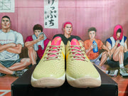 Front view showing the textured green uppers, pink tongues, and laces