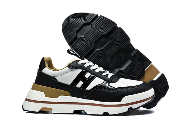 Black and white low-top sneakers with tan accents, shown from the side with the black outsole visible.
